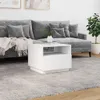 A white coffee table is placed in front of a grey sofa in a living room setting. Voir les images du produit