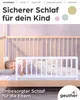 A child sleeping in a crib with a bed rail. Produktbild-Vorschau