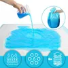 A hand pouring blue liquid onto a white absorbent pad, with inset graphics illustrating absorbency and layering. Produktbild-Vorschau