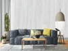 A living room scene with a sofa, coffee table, and decorative items, showcasing the wallpaper. Podgląd zdjęcia produktu
