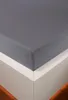A close-up of a grey fitted sheet on a white bed frame. Produktbild-Vorschau