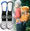 A woman wearing a backpack and a hat, with two compass watches attached to her backpack. Produktbild-Vorschau