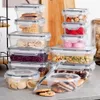 A collection of clear plastic food storage containers with gray lids, filled with various food items like cookies, pasta, and beans, arranged on a countertop. Náhled obrázku produktu