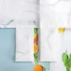 A close-up view of a white fabric with an embossed pattern, partially covering slices of oranges and green leaves. Produktbild-Vorschau