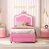 A pink upholstered twin bed with a crown-shaped headboard and LED lighting, set in a child's bedroom. Voir les images du produit
