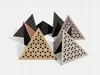 A collection of triangular acoustic foam panels with perforated wooden fronts arranged on a white surface. Podgląd zdjęcia produktu