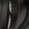 A close-up view of black leather material with stitching and a white logo. Náhľad obrázku produktu