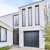 A modern house with a garage and a large window. Produktbild-Vorschau