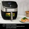 An Instant Pot Vortex Plus Airfryer is shown on a kitchen counter next to a plate of cooked salmon and broccoli. The airfryer has a clear window showing food inside. Produktbild-Vorschau
