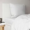 A close-up view of a white bed with a pillow and duvet. Produktbild-Vorschau