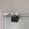 A close-up view of a sliding glass door hardware system mounted on a track against a concrete wall. Anteprima dell’immagine prodotto