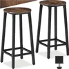 Two bar stools with wooden seats and black metal frames are shown against a white background. Náhled obrázku produktu