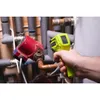 A hand holding a Ryobi infrared thermometer and pointing it at plumbing equipment. Produktbild-Vorschau