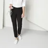 A person wearing black pants and white shoes, holding two wine glasses. Produktbild-Vorschau