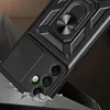 A black phone case with a ring holder and camera cover is shown in a dramatic, angled shot, with cracked ground effects suggesting durability. Anteprima dell’immagine prodotto