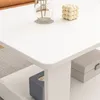 A close-up view of a white coffee table with decorative items and storage boxes. Náhled obrázku produktu