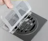 A hand is shown placing a mesh cover over a stainless steel shower drain. Podgląd zdjęcia produktu