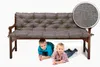 Two children are lying under a bench with a gray cushion. Produktbild-Vorschau