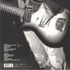 A person playing a guitar, with ripped jeans visible. Produktbild-Vorschau