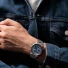A man wearing a denim jacket and a watch. Produktbild-Vorschau