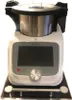 A kitchen appliance with a touchscreen and a silver dial is shown on a black base with silver supports. Produktbild-Vorschau