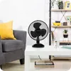 A table fan is placed on a white coffee table in a living room setting. Anteprima dell’immagine prodotto