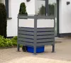 A grey metal bin enclosure with white panels is shown outdoors on a paved driveway, with a blue bin inside. Náhled obrázku produktu