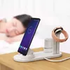 A person sleeping in the background while a smartphone, smartwatch, and earbuds are charging on a white charging station. Produktbild-Vorschau