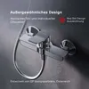 A close-up studio shot of a modern chrome shower faucet against a dark, textured background. Produktbild-Vorschau