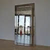A full-length mirror with a decorative frame and a diamond-patterned glass surface, standing against a wall. Produktbild-Vorschau