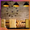 A large, modern wall clock with Roman numerals is mounted on a brick wall above a row of tufted leather seating in a cafe or lounge setting. Two industrial-style pendant lights hang above the clock. Náhled obrázku produktu