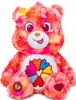 A plush toy bear with a colorful tie-dye pattern and a flower emblem on its chest. Anteprima dell’immagine prodotto