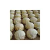 A close-up view of many small, shell-shaped cookies filled with white cream and decorated with silver edible pearls. Produktbild-Vorschau