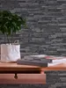 A close-up of a desk with a plant, books, and an open drawer, set against a stone-effect wallpaper. Náhľad obrázku produktu