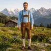 Kniebund Lederhose mit Hosenträgern getragen von einem Mann auf einer Blumenwiese vor alpiner Bergkulisse Produktbild-Vorschau
