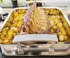 A close-up of a roasted rack of lamb with potatoes in a roasting pan. Produktbild-Vorschau