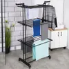 A black metal drying rack with multiple shelves, holding various folded towels and a sweater, in a bathroom setting with tiled walls and a cabinet. Produktbild-Vorschau