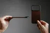 Hands holding a phone case and a phone, showing the case's slim profile and its attachment mechanism. Produktbild-Vorschau