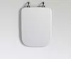 A white toilet seat lid is shown from a top-down perspective, attached to a white wall by two chrome hinges. Produktbild-Vorschau