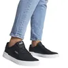 A person wearing blue jeans and black Puma sneakers. Podgląd zdjęcia produktu