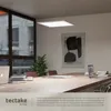 A modern office meeting room with a large wooden table, chairs, laptops, and a hanging LED panel light. Produktbild-Vorschau
