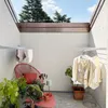 An outdoor patio or balcony area with laundry drying on wall-mounted racks. Produktbild-Vorschau