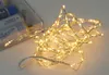 A coiled string of warm white LED lights with a battery pack in the background. Produktbild-Vorschau