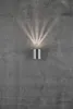 A silver cylinder-shaped wall light mounted on a textured gray concrete wall, emitting a fan of light upwards. Anteprima dell’immagine prodotto