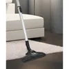 A vacuum cleaner head on a rug next to a sofa. Produktbild-Vorschau
