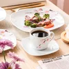 A table setting with a meal and coffee, featuring floral-patterned dishes. Voir les images du produit