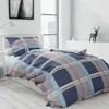 A neatly made bed with blue plaid bedding in a bright, modern bedroom. Podgląd zdjęcia produktu
