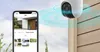 A security camera mounted on a wall, with a smartphone displaying its interface in the foreground. Anteprima dell’immagine prodotto