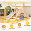 Two young children playing on a wooden climbing triangle with a slide in a brightly lit playroom with shelves and a large rug. Produktbild-Vorschau