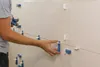 A person is installing tiles on a wall using leveling clips. Náhľad obrázku produktu